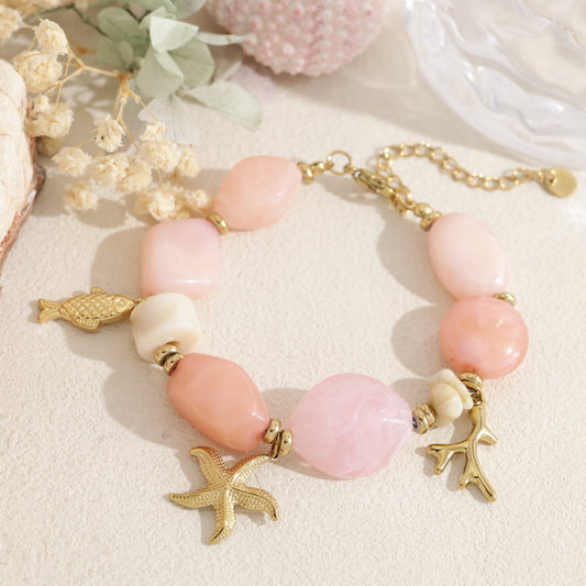 Bracelet doré perle en résine rose pendentif marin