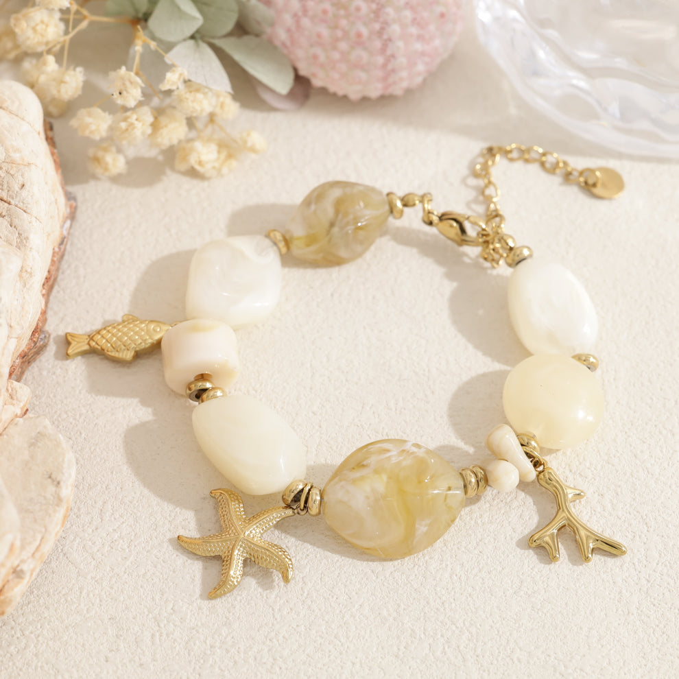 Bracelet doré perle en résine rose pendentif marin