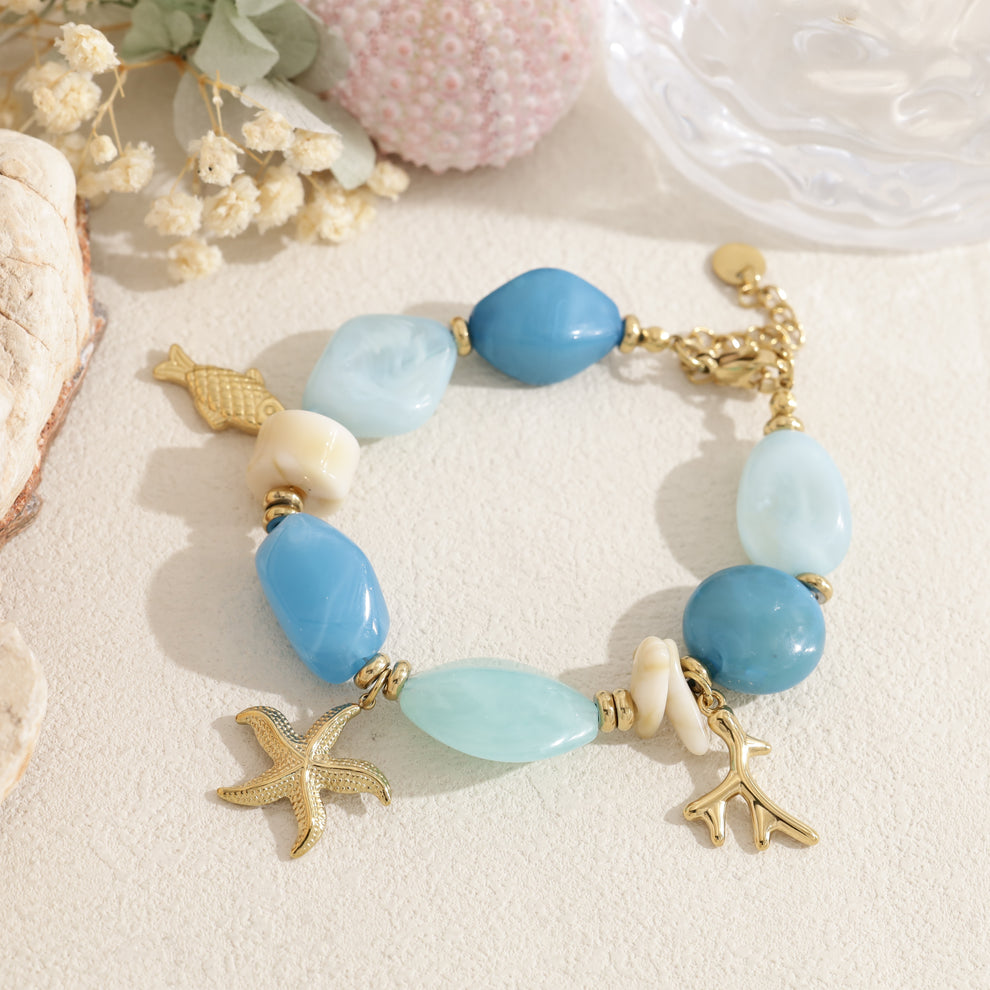 Bracelet doré perle en résine rose pendentif marin