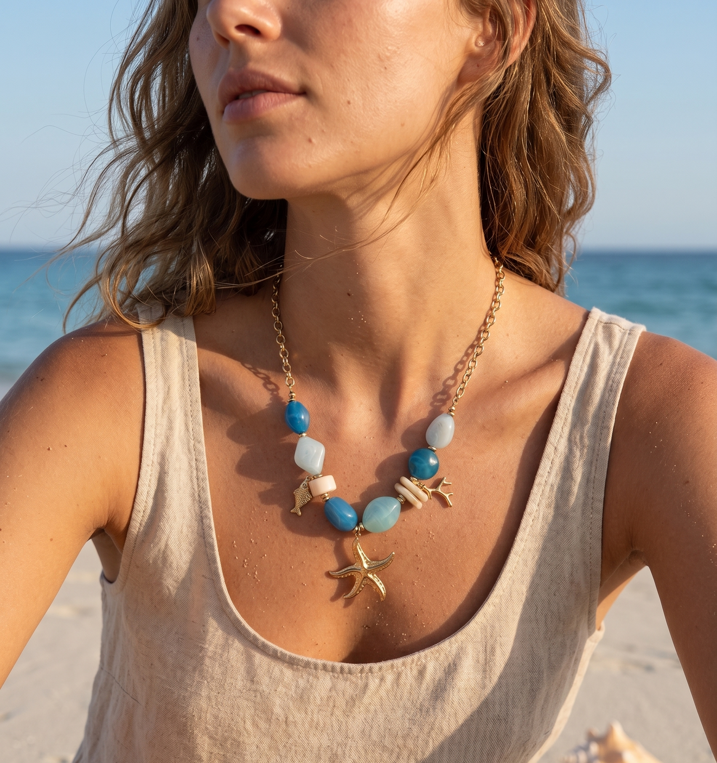 Collier doré perle en résine beige pendentif marin
