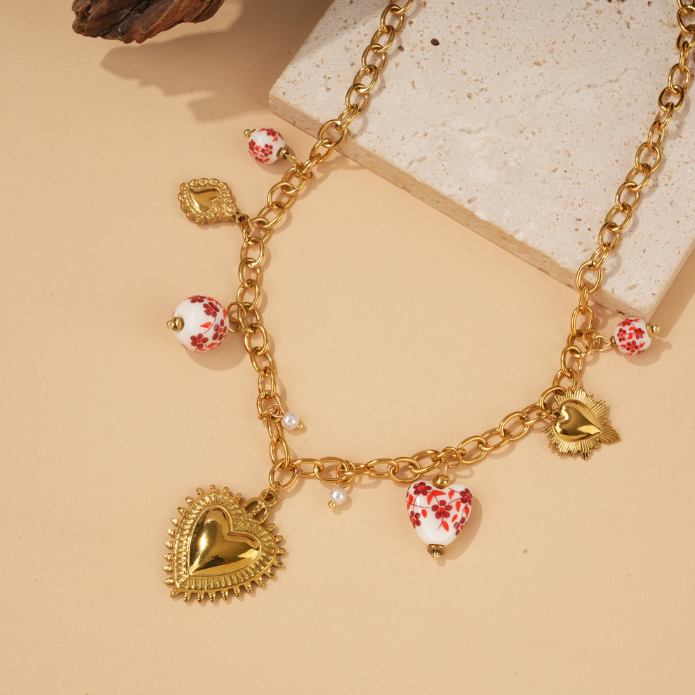 Collier doré à charms cœur texturé et perle en porcelaine rouge